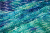 A 3D textured abstract embroidery fabric with a plush feel, in a palette of blue and green