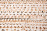 A fine beaded embroidery fabric, with a vertical stripe pattern made of tiny floral and starburst motifs in champagne-pink and pewter.