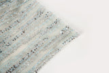 A fine beaded embroidery fabric, with a vertical dashed-line pattern resembling rain, in shades of ice blue and silver.