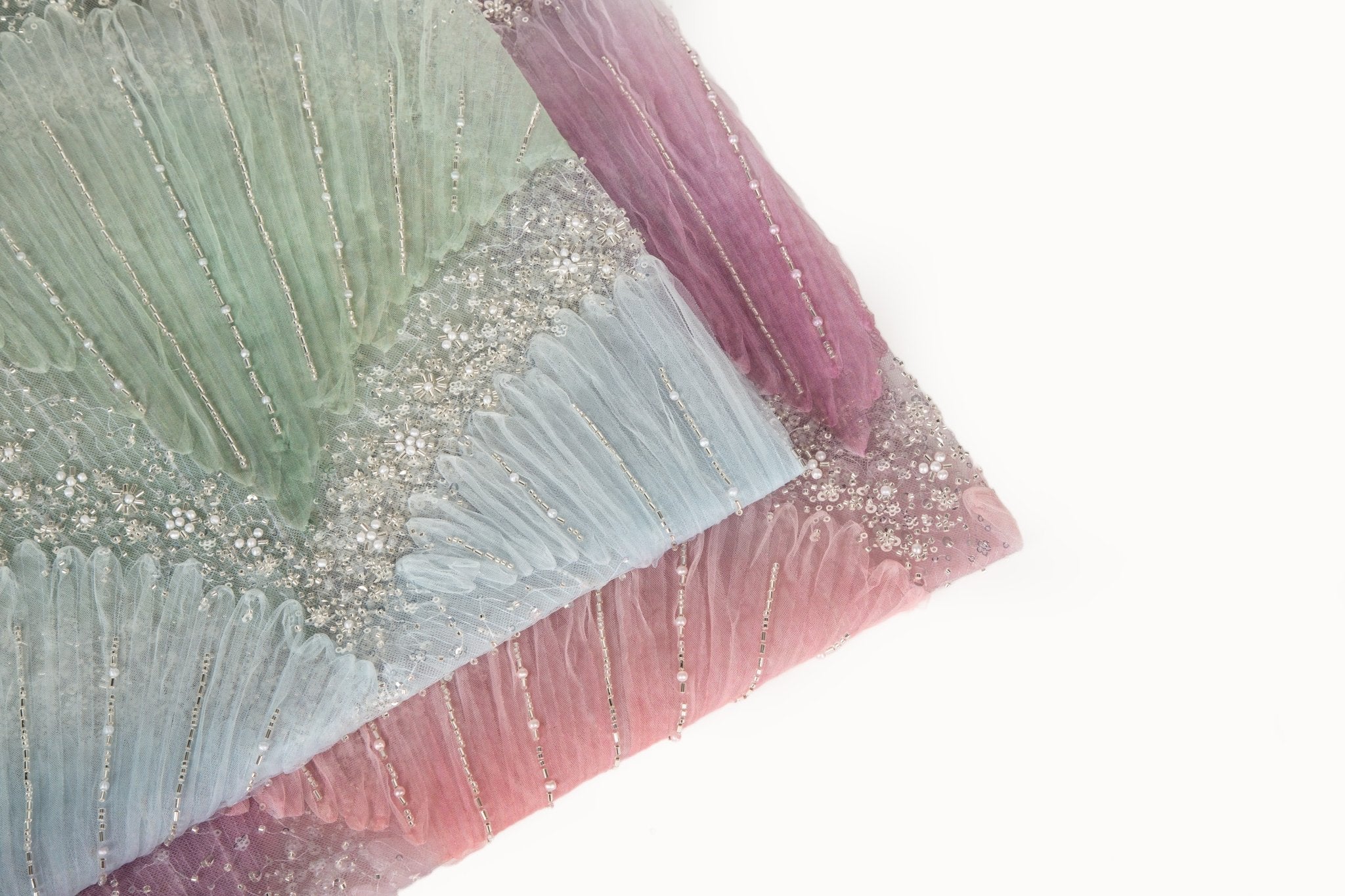 A 3D embroidery fabric with ribbon scallop motifs in a yellow, green, blue, and lilac gradient.
   A 3D embroidery fabric with ribbon scallop motifs in a pink and lilac gradient.