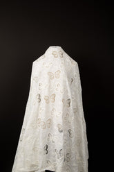 A white laser-cut lace fabric, featuring an all-over pattern of butterflies in various sizes.