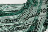An emerald green Art Deco beaded fabric, with concentric, eye-shaped patterns in black sequins and beads.