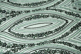 An emerald green Art Deco beaded fabric, with concentric, eye-shaped patterns in black sequins and beads.