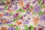A 3D textured embroidery fabric with a plush feel, in a palette of purple, pink, and green.