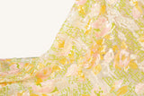 A sequin embroidery fabric on white mesh with yellow-pink florals over green geometric patterns.