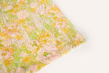 A sequin embroidery fabric on white mesh with yellow-pink florals over green geometric patterns.