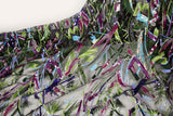 An abstract embroidery fabric on black tulle, with a graffiti-like pattern of lines made from neon green, pink, and purple sequins and thread.