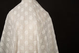 An ivory-white flat embroidery organza fabric, with a pattern combining a grid and floral-filled polka dots.