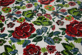 A sequin floral embroidery fabric on a black base, with red and green motifs.