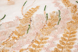 A hand-beaded embroidery fabric, with a vertical, wavy pattern of laurel leaves in rose gold, pink, and green.