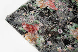 A painterly floral sequin and thread embroidery fabric on a black mesh base with richly colored flowers.