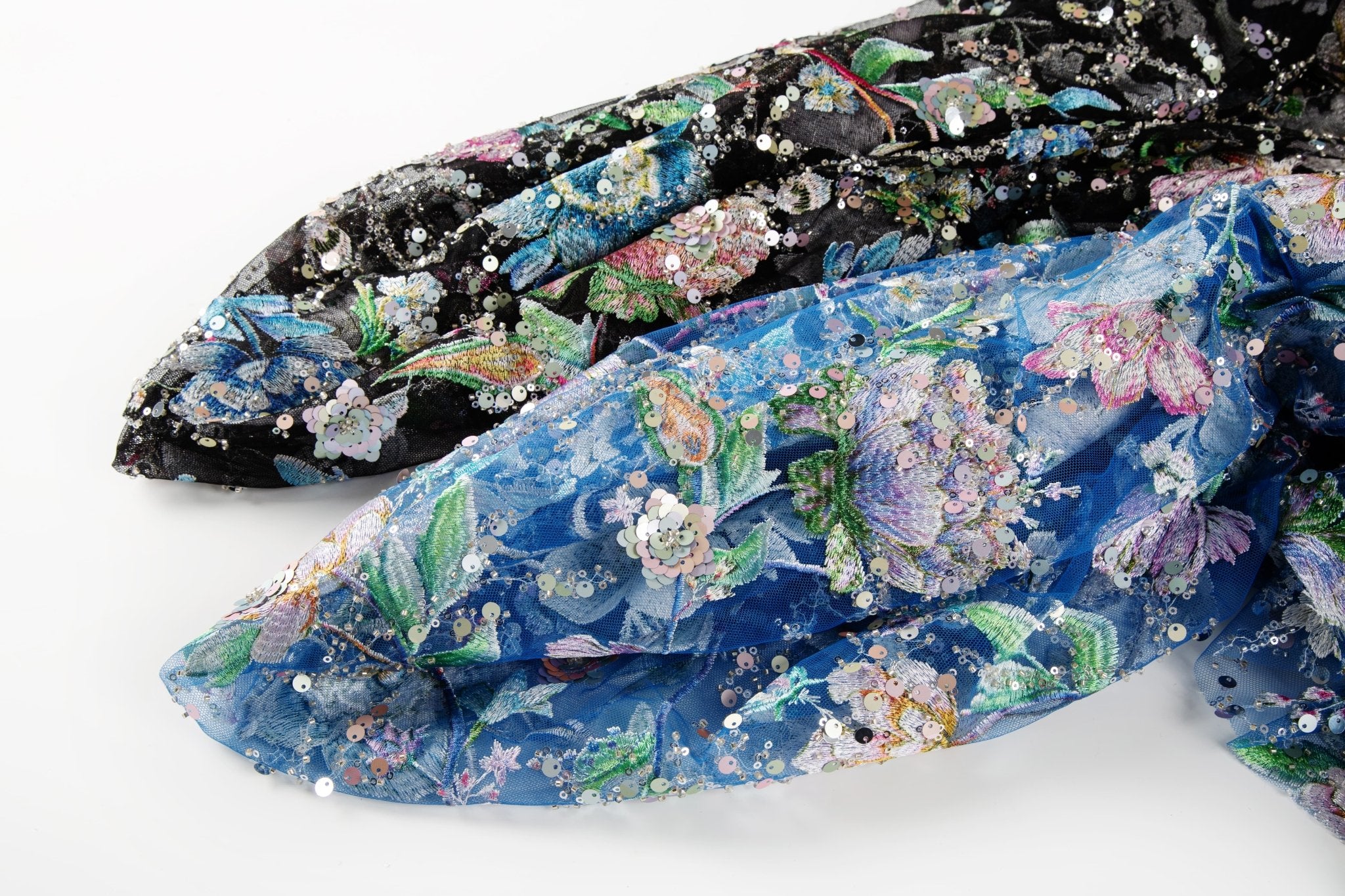 A multi-color floral sequin embroidery fabric on a black mesh base.
  A multi-color floral sequin embroidery fabric on a sapphire blue mesh base.