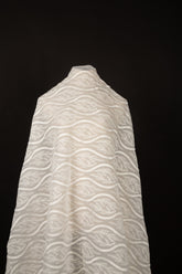 An ivory-white flat embroidery organza fabric, with a horizontal striped pattern of wavy lines and fern-like leaves.