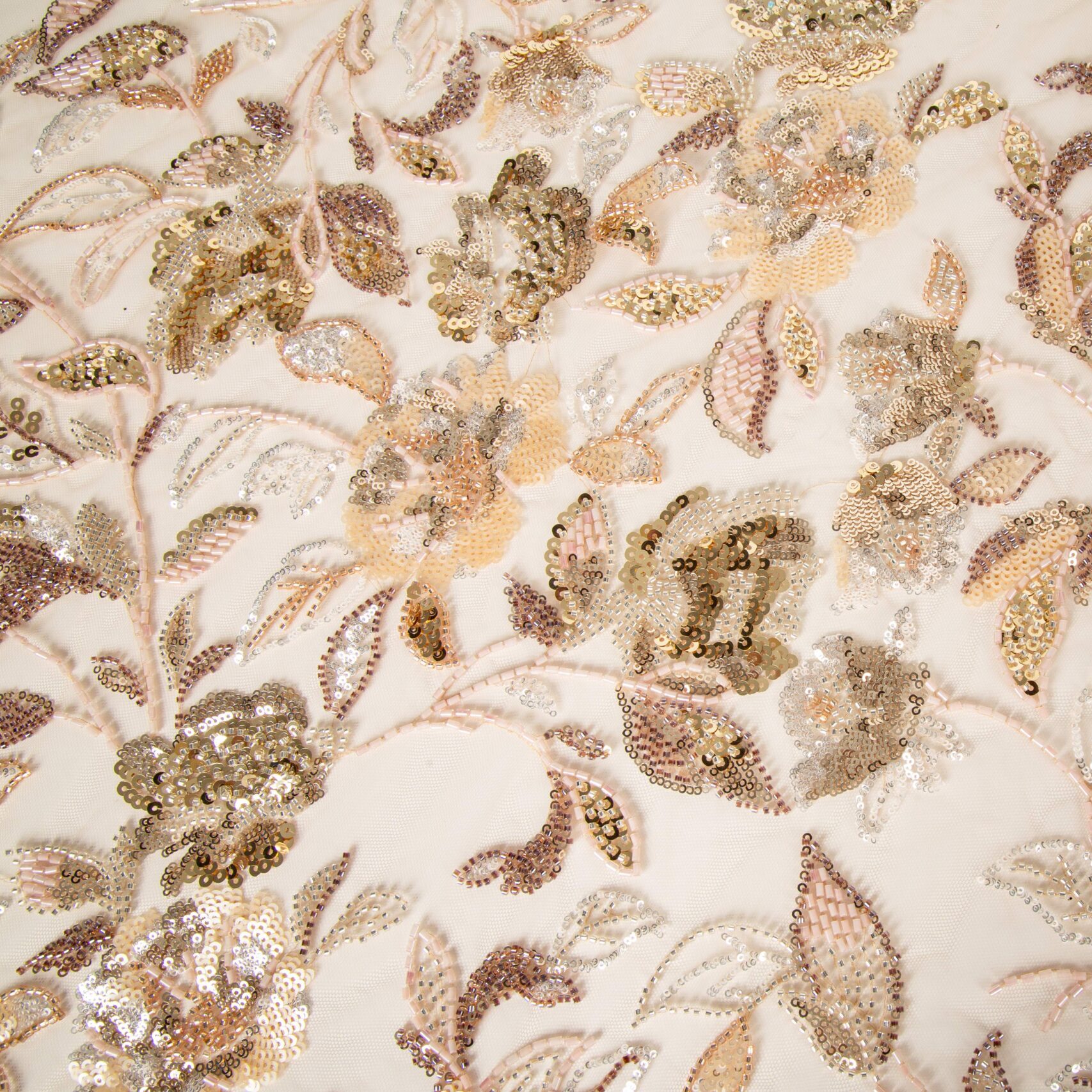 lose-up of integrated sequin and glass bead floral embroidery on a delicate mesh base, demonstrating precision multi-material registration for premium apparel.