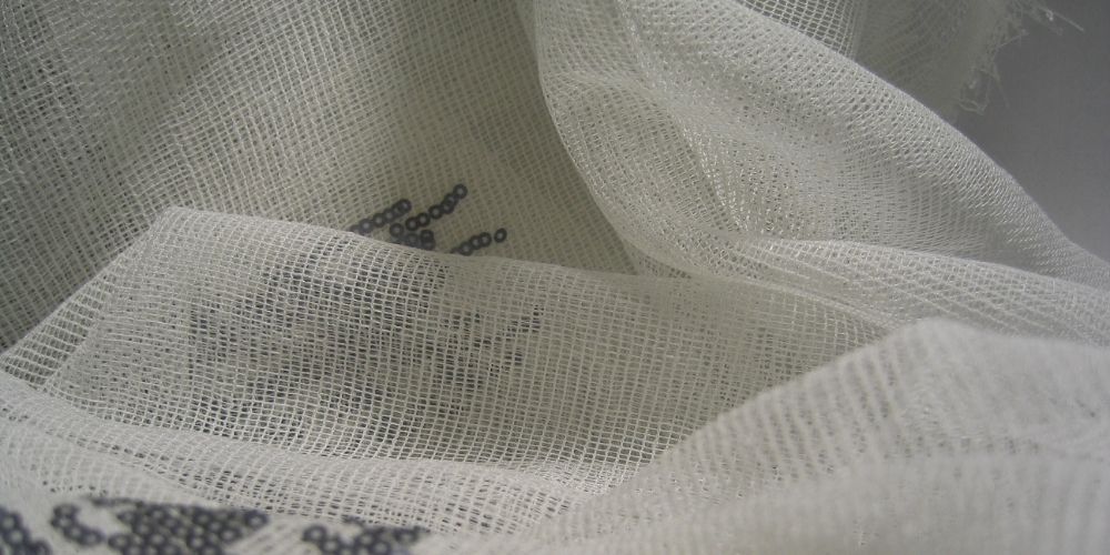 Premium sheer organza fabric by the yard used as a base for heavy sequin embroidery.
