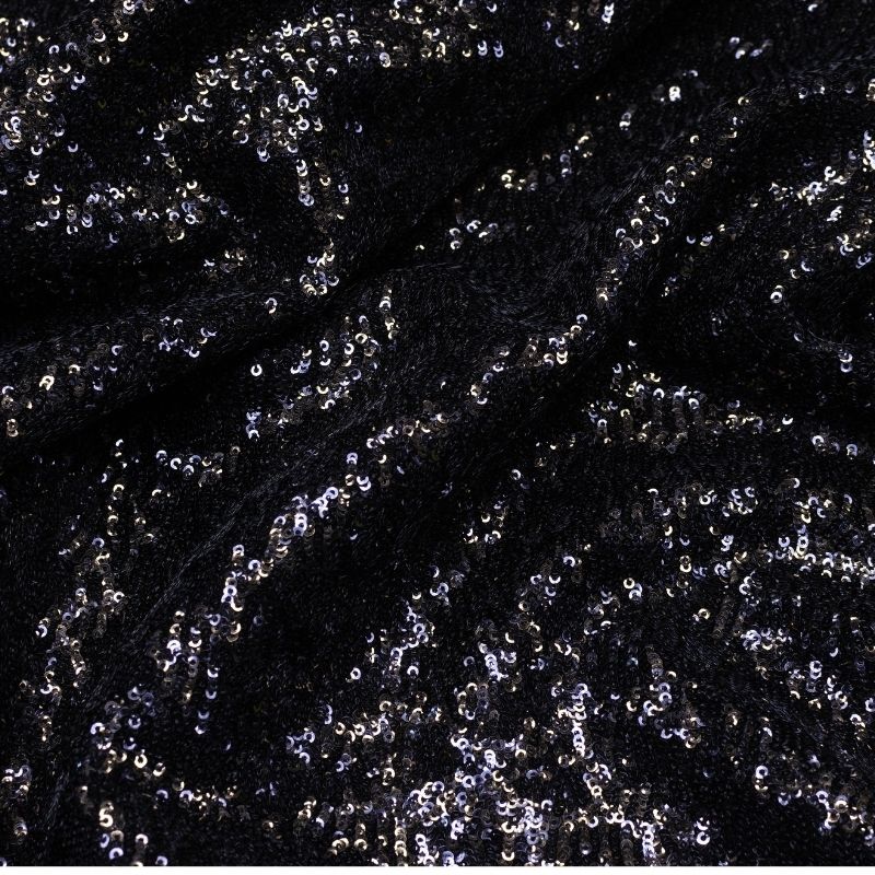 A close-up view of densely embroidered smooth black fabric and structured black cloth material, demonstrating complete opacity with zero base show-through.