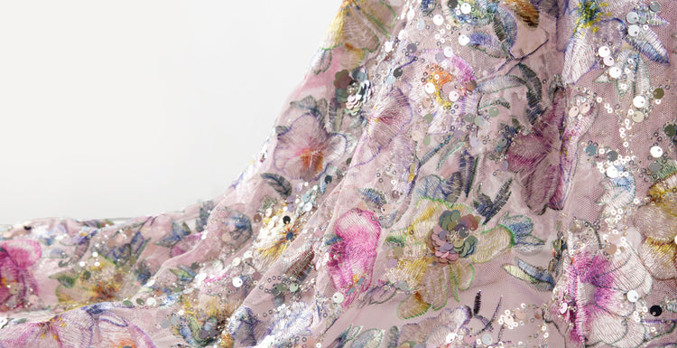 A purple embroidered fabric, using sequin embroidery and bead embroidery techniques