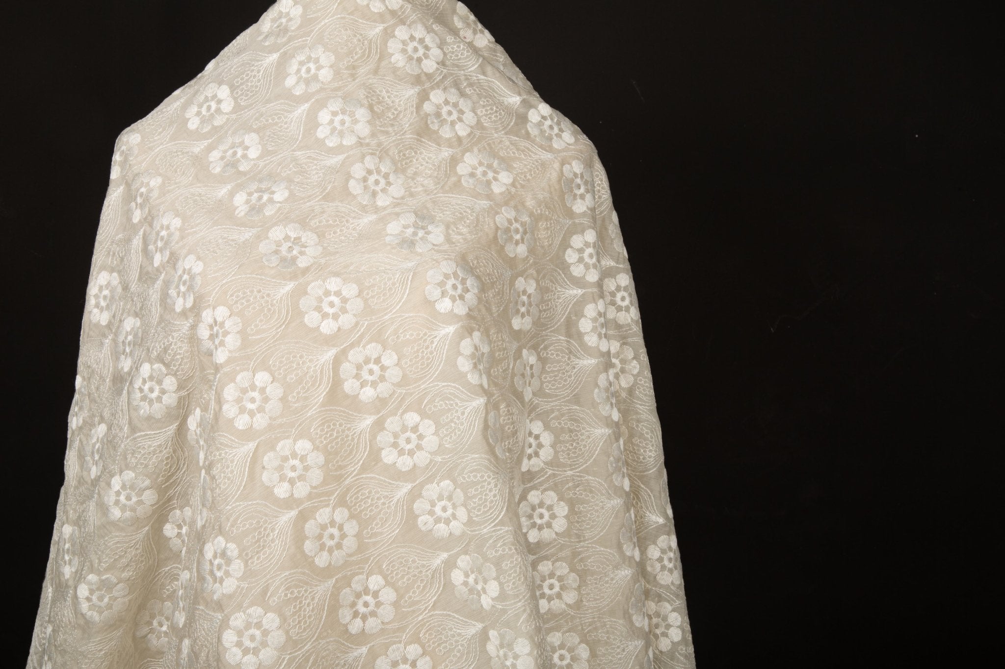 An ivory-white flat embroidery organza fabric, with a repeating, damask-style floral pattern.
