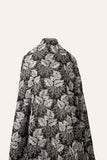 A black and white embroidered cotton fabric, with a stylized pattern of large leaves and coral, resembling a woodcut print.
