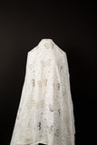A white laser-cut lace fabric, featuring an all-over pattern of butterflies in various sizes.