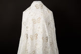 A white laser-cut lace fabric, featuring an all-over pattern of butterflies in various sizes.