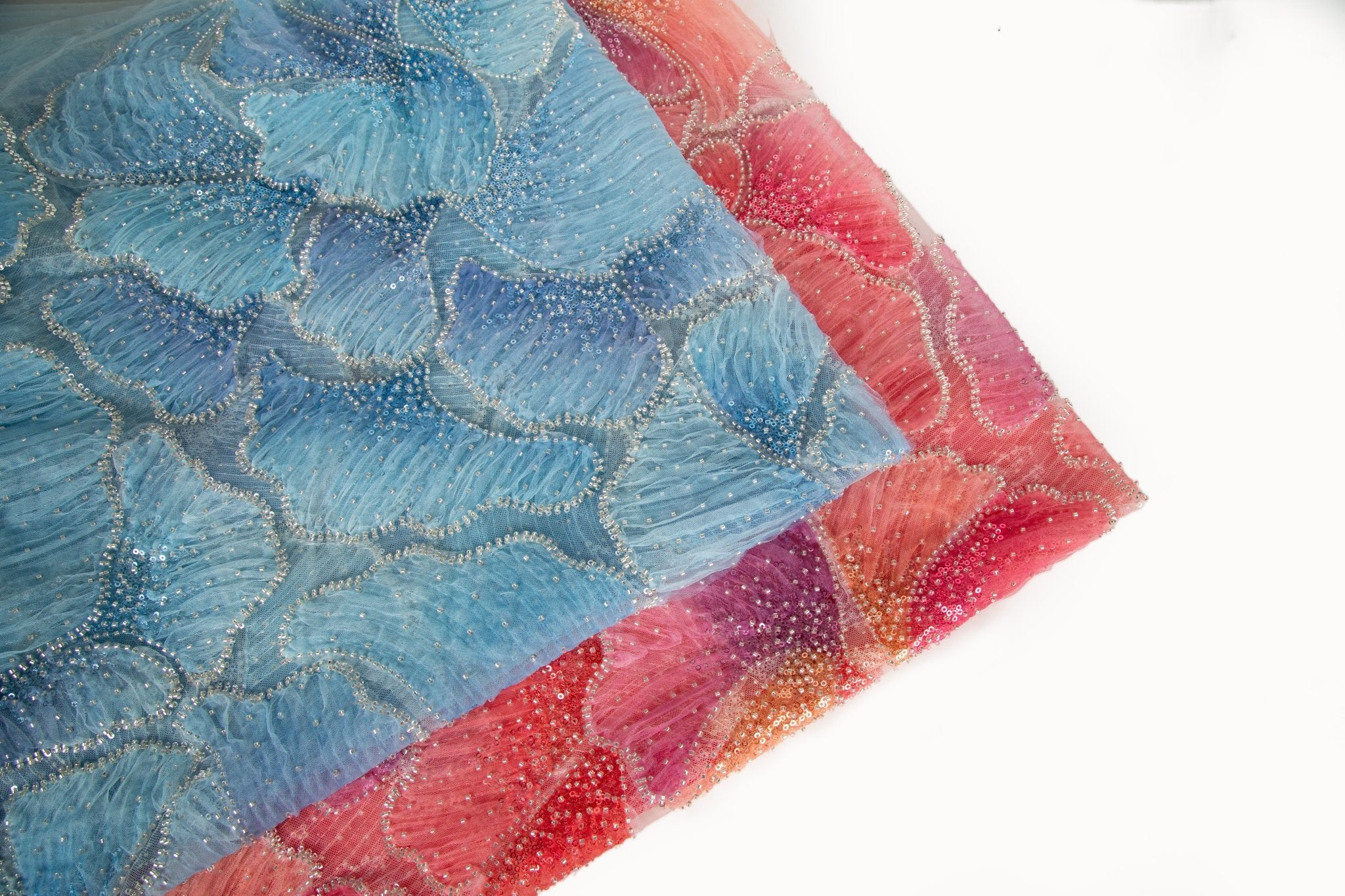    A 3D ribbon and bead embroidery fabric, with feathered petal motifs in a blue gradient.
   A 3D ribbon and bead embroidery fabric, with feathered petal motifs in a coral and purple gradient.
