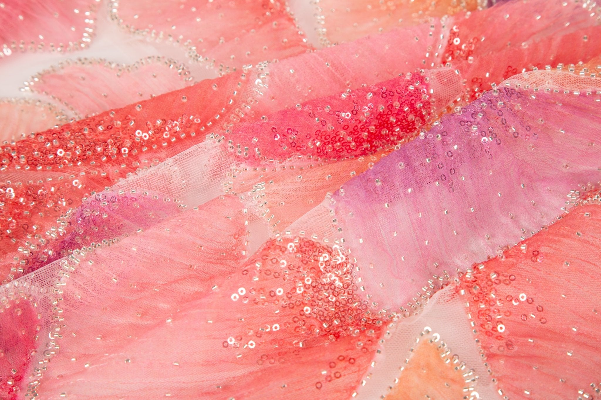 A 3D ribbon and bead embroidery fabric, with feathered petal motifs in a coral and purple gradient.
