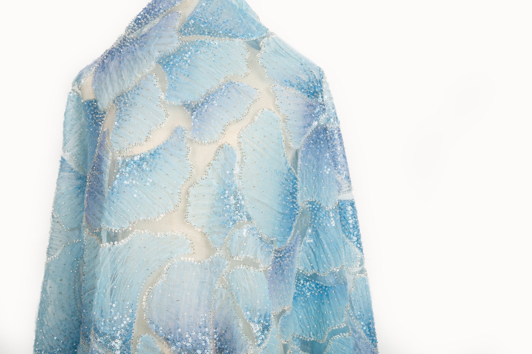  A 3D ribbon and bead embroidery fabric, with feathered petal motifs in a blue gradient.

