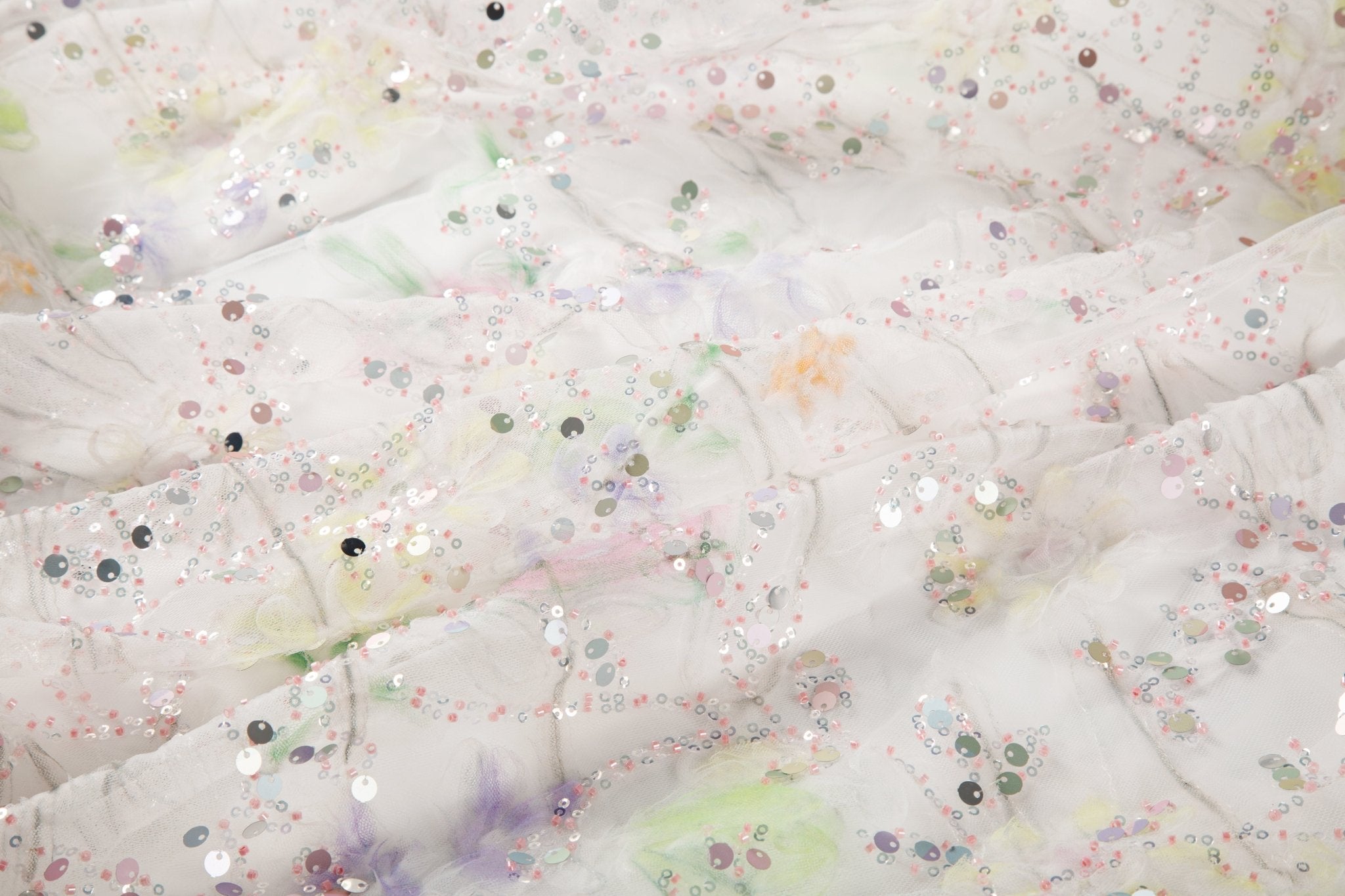 A 3D ruched embroidery fabric with a soft texture, in a palette of mint green, lilac, and pink.
