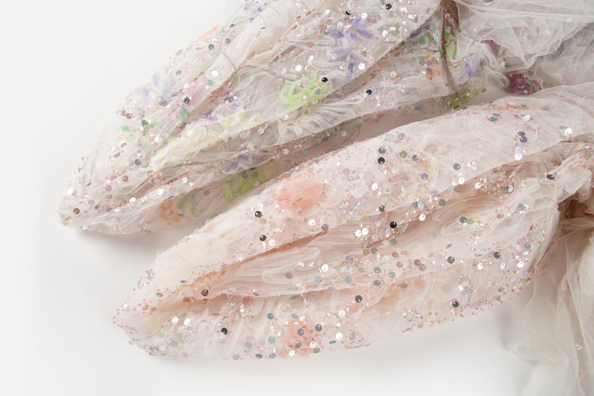    A 3D ruched embroidery fabric with a soft texture, in a palette of mint green, lilac, and pink.
   A 3D ruched embroidery fabric with a soft texture, in a palette of peach-pink and cream.
