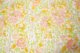 A sequin embroidery fabric on white mesh with yellow-pink florals over green geometric patterns.

