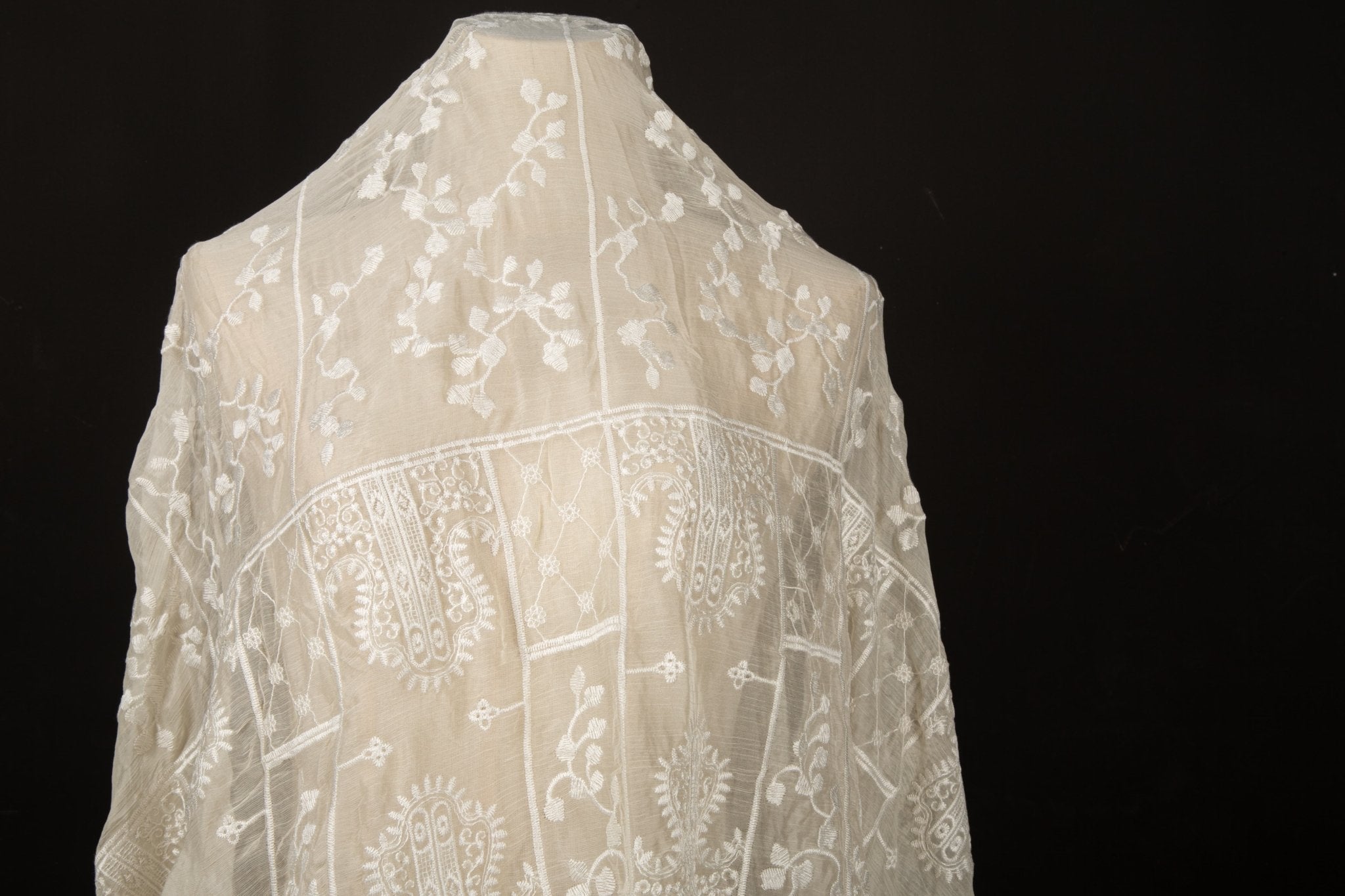 An ivory-white flat embroidery organza fabric, with a horizontal striped pattern of floral friezes and vines.
