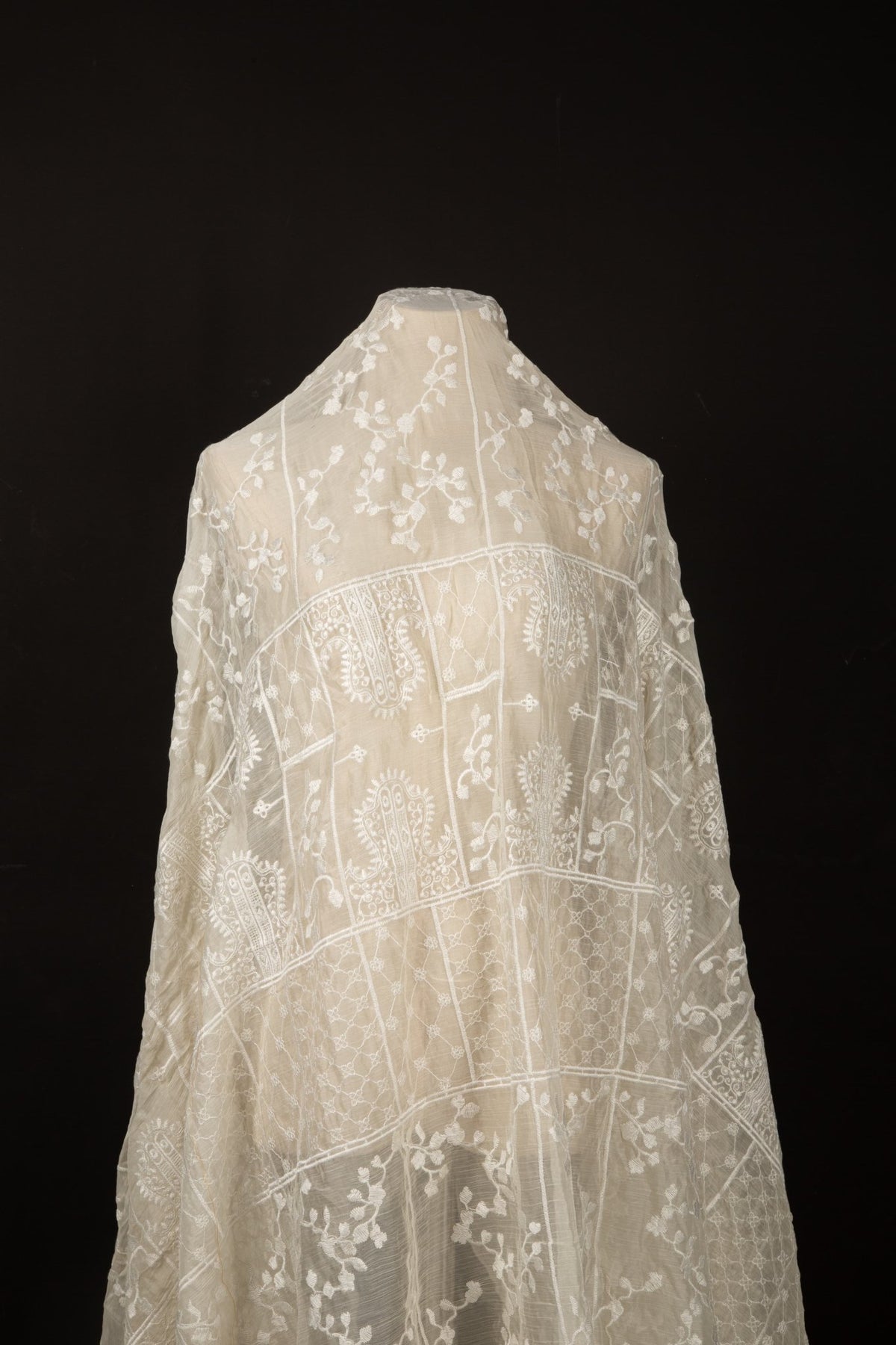 An ivory-white flat embroidery organza fabric, with a horizontal striped pattern of floral friezes and vines.
