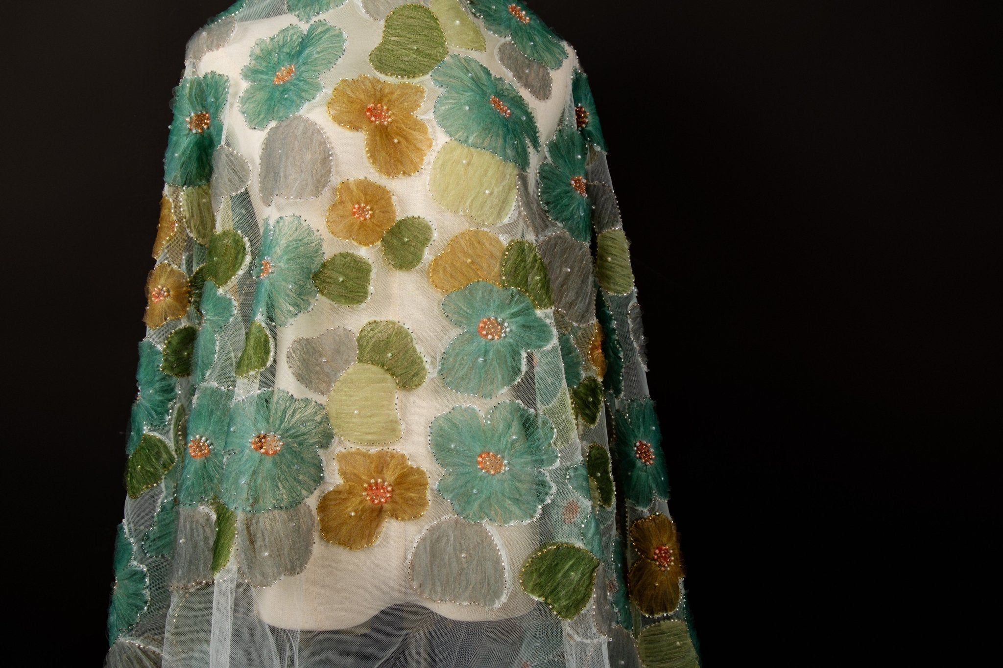 Green, ochre, and grey crinkle ribbon embroidered floral fabric.