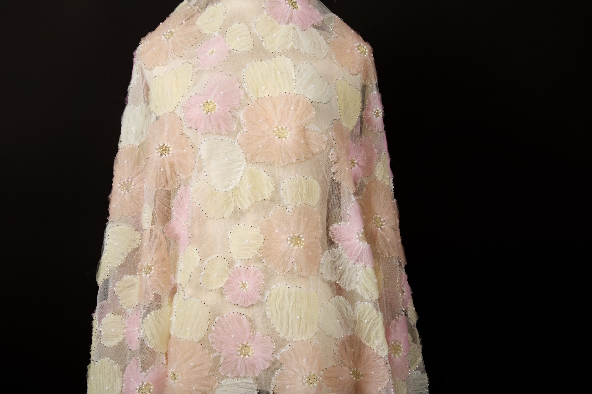 Pink, light green, pale blue, and white crinkle ribbon embroidered floral fabric.
