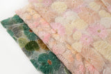    Pink, light green, pale blue, and white crinkle ribbon embroidered floral fabric.  
   Green, ochre, and grey crinkle ribbon embroidered floral fabric.
    