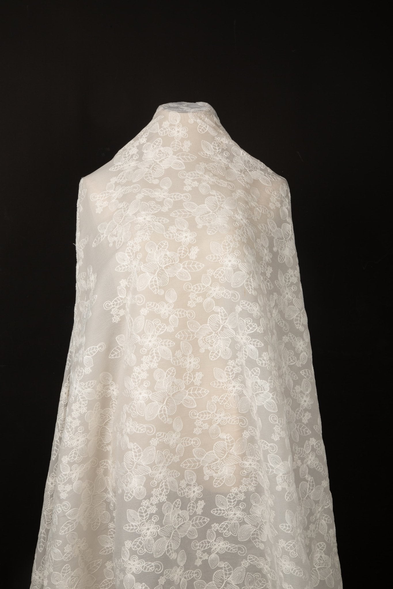 An ivory-white flat embroidery organza fabric, with an abstract, continuous-line floral pattern resembling line art.
