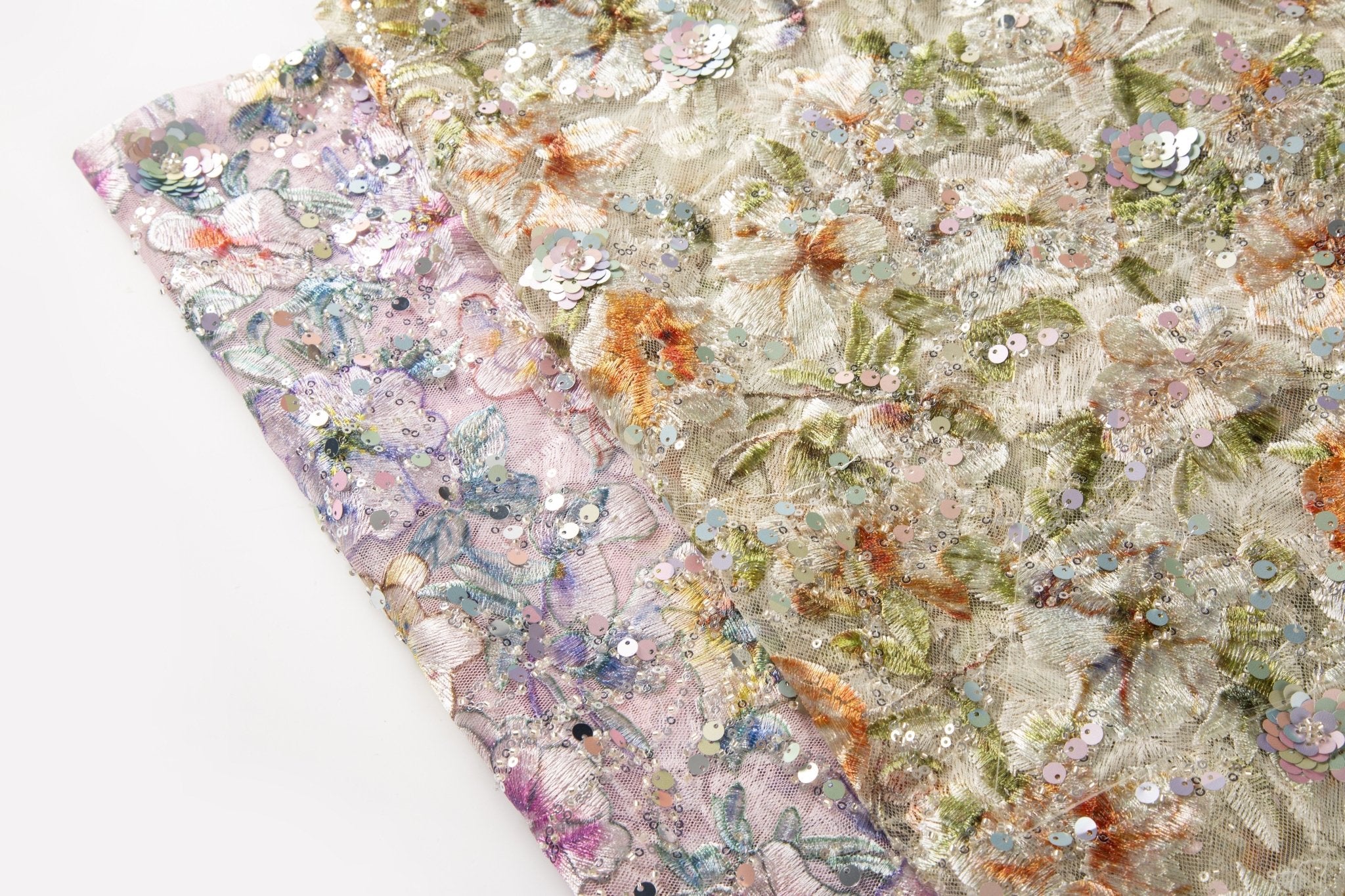    A dense, painterly floral sequin and thread embroidery fabric in a warm palette of greens and oranges.
    A dense, painterly floral sequin and thread embroidery fabric in a cool palette of purples and blues.
