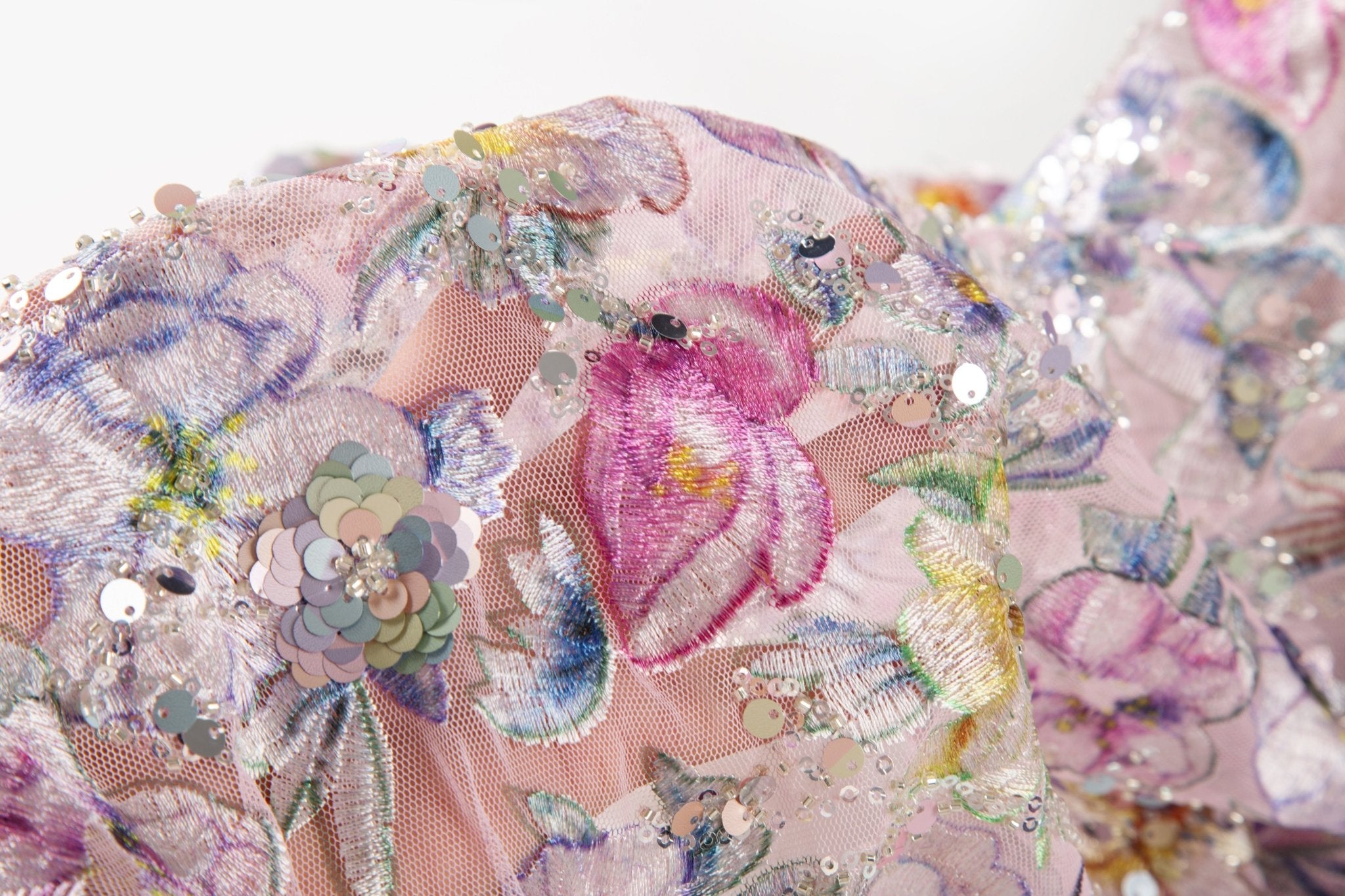 A dense, painterly floral sequin and thread embroidery fabric in a cool palette of purples and blues.
