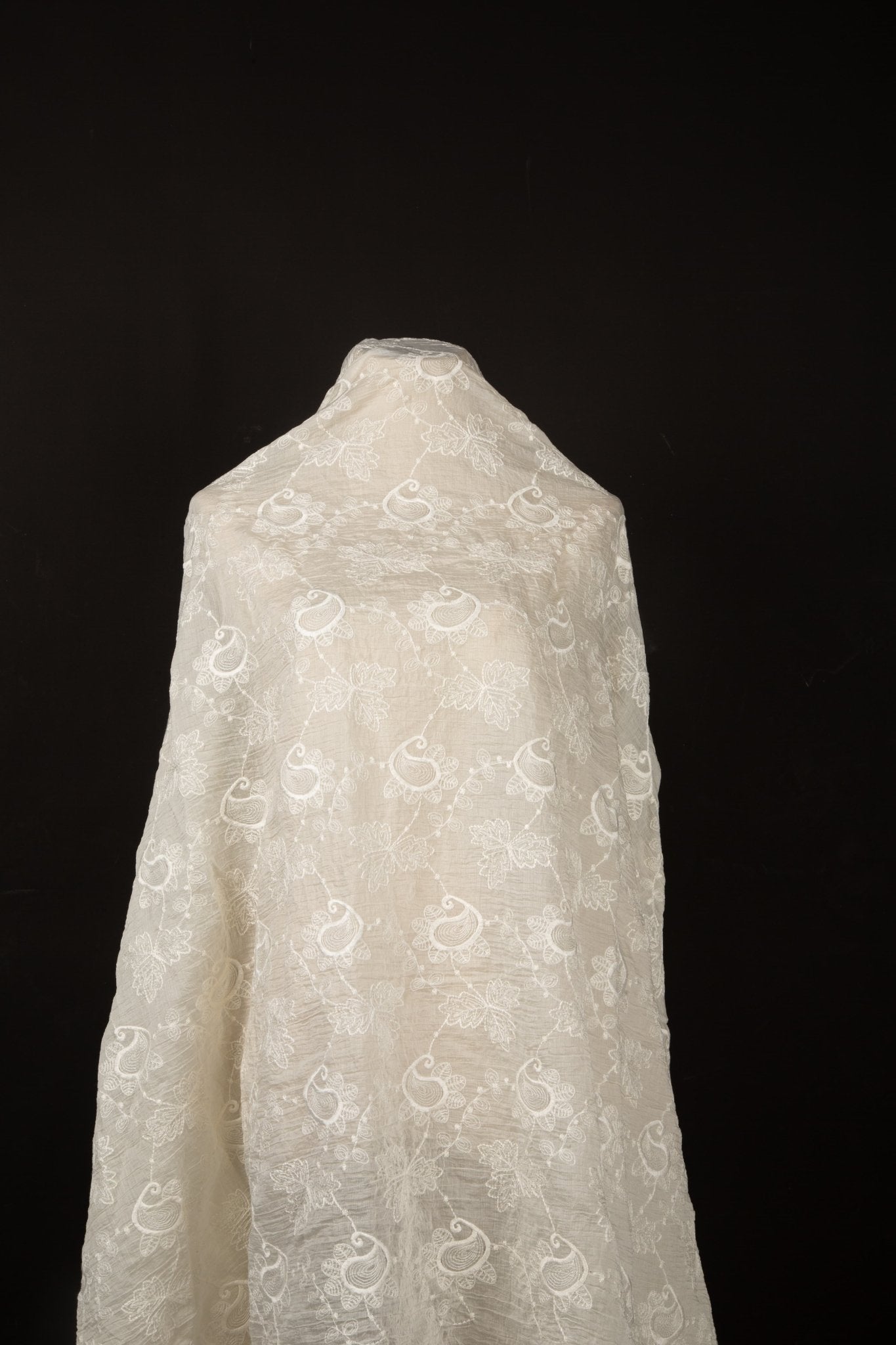 An ivory-white flat embroidery cotton fabric, with a repeating, classic paisley pattern.
