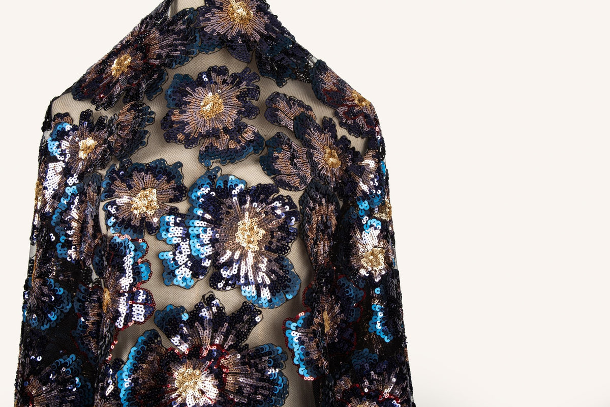  A large floral sequin embroidery fabric on a black base, with blue and gold motifs.
