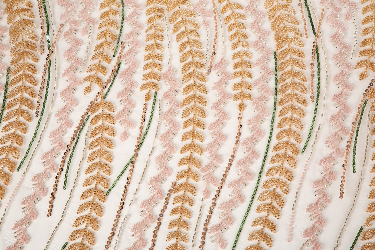 A hand-beaded embroidery fabric, with a vertical, wavy pattern of laurel leaves in rose gold, pink, and green.
