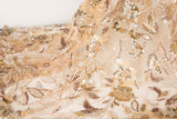 A luxurious beaded embroidery fabric, with a dense, trailing floral vine pattern in a warm rose gold and pink palette.
