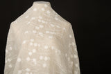 An ivory-white crinkle cotton embroidery fabric, with a horizontal wavy pattern of polka dots and thorny vine lines.
