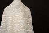 An ivory-white flat embroidery organza fabric, with a horizontal striped pattern of wavy lines and fern-like leaves.
