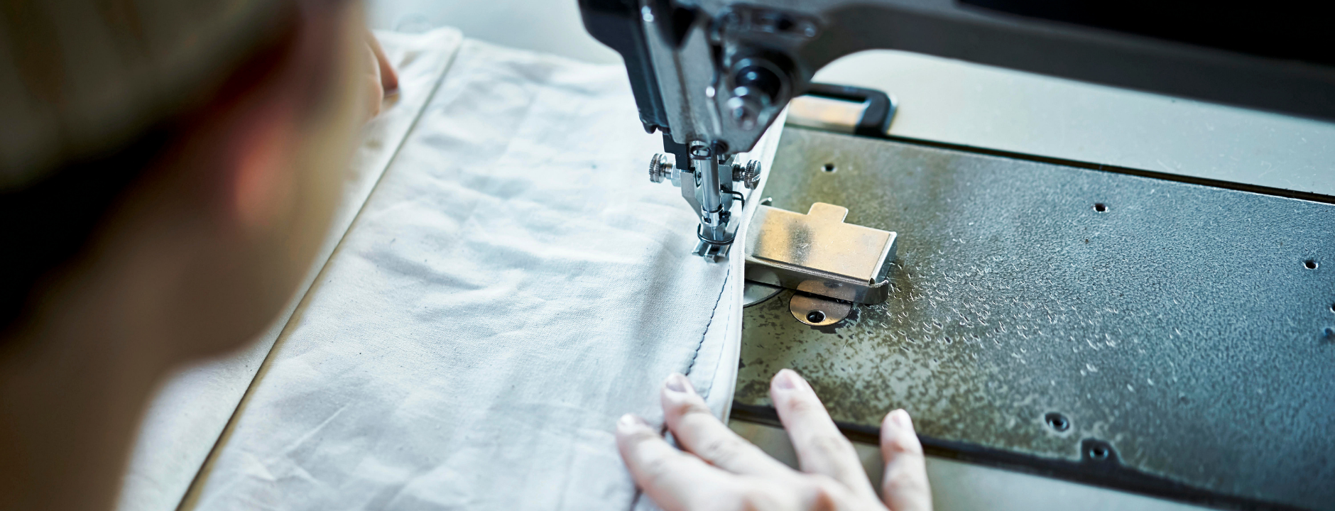 Explore Our Custom Fabric Portfolio Industrial sewing machine used in the custom fabric manufacturing process for premium fashion textiles