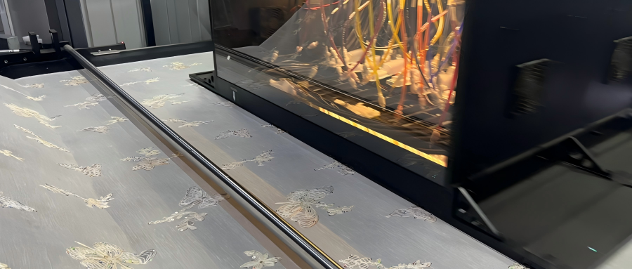 Vision-guided digital position printing machine producing floral border print fabric, showing camera alignment, fabric layout control, color swatches, and fashion textile development workspace.