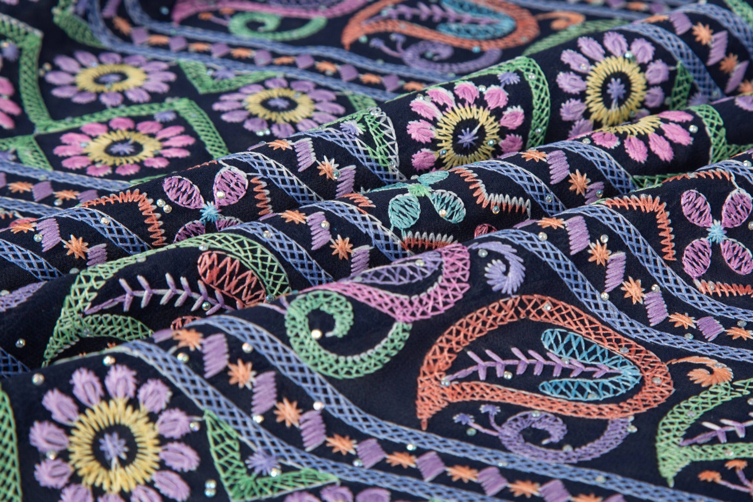 High-density all-over flat embroidery that completely covers the base fabric, showing a rich and durable surface for bulk manufacturing.