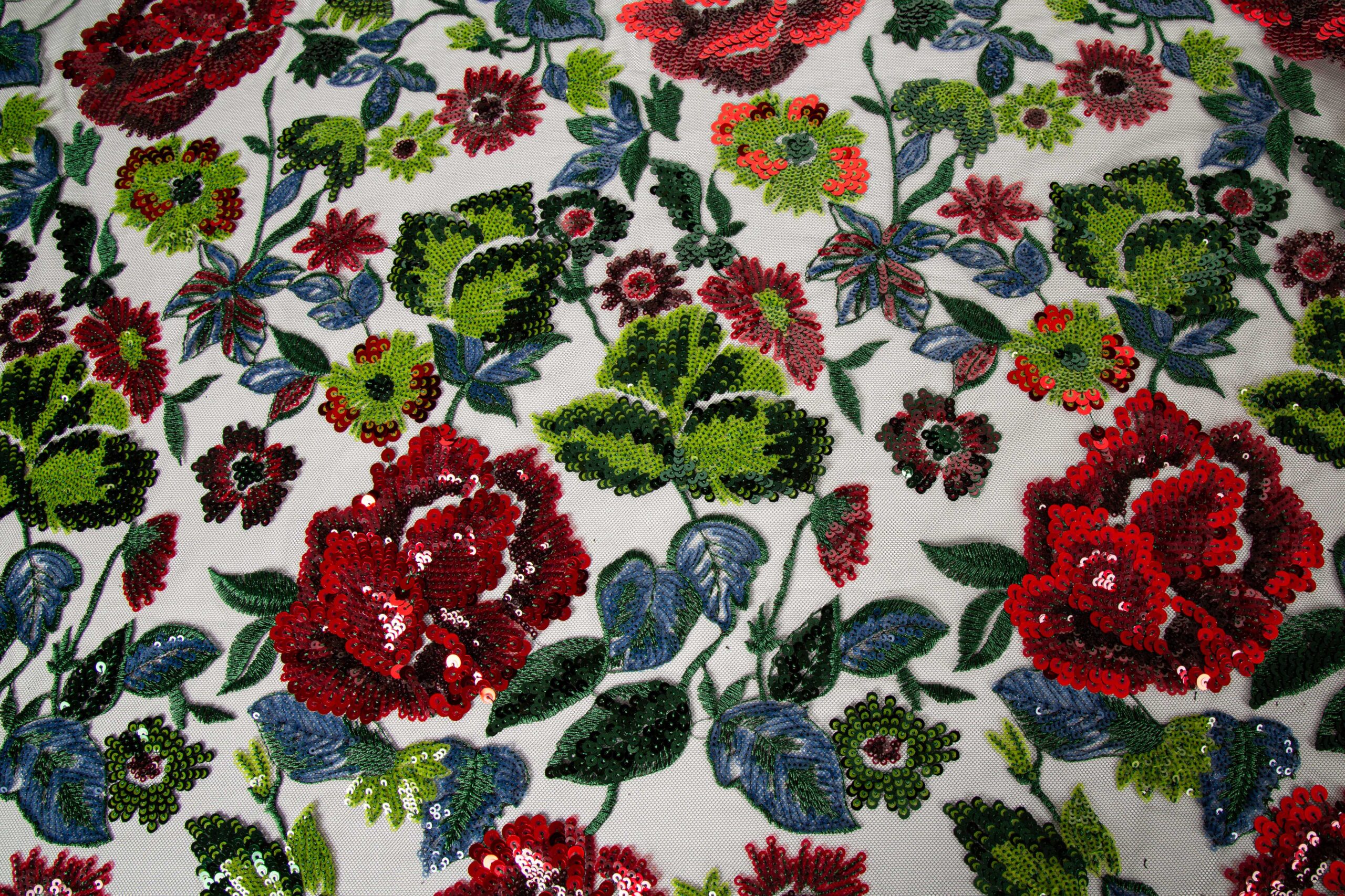 High-density multi-color floral sequin embroidery on white mesh fabric, illustrating flawless pattern overlap and high-speed stitching stability for bulk production.