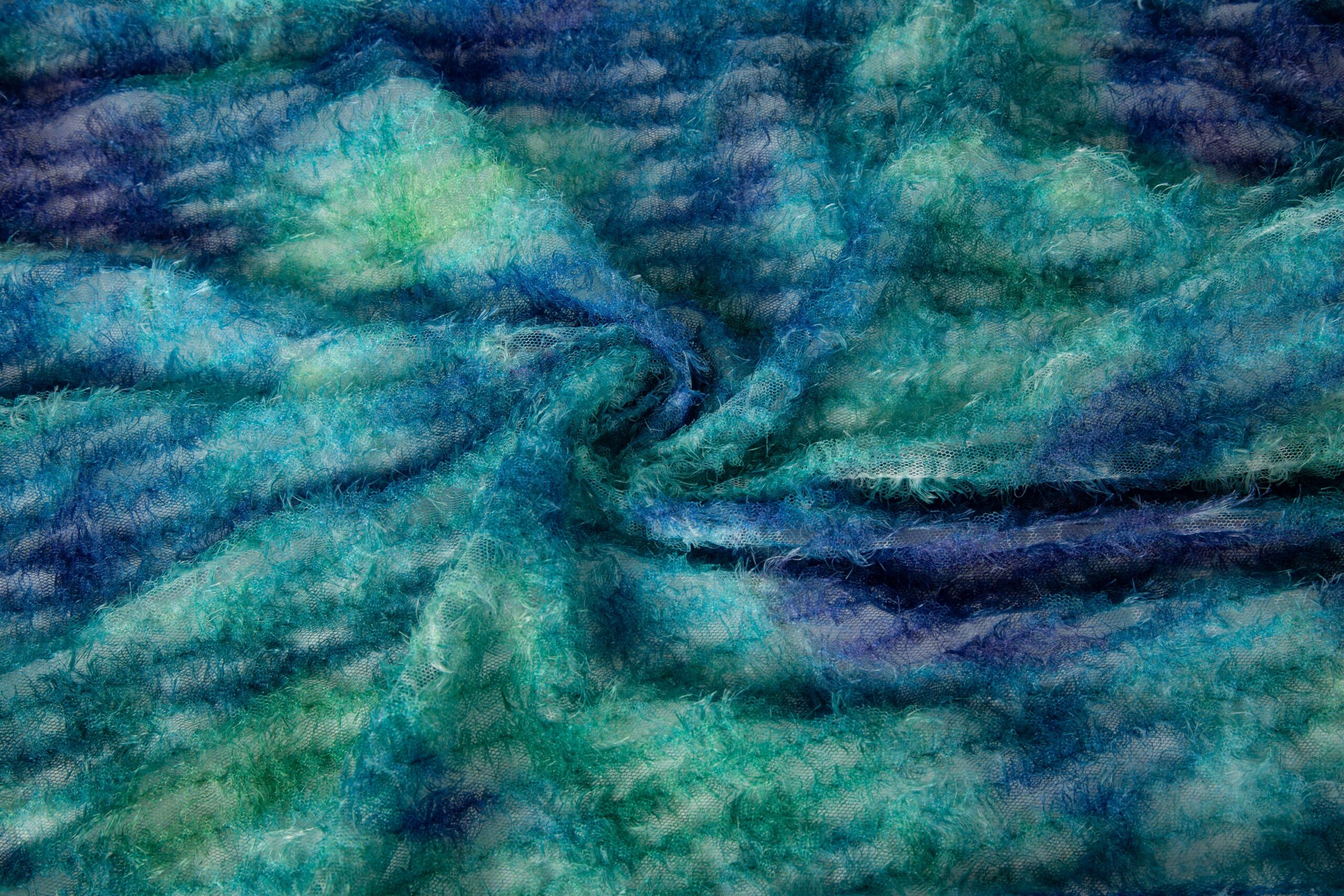 Detailed shot of chain stitch embroidery with thick thread loops, showcasing rich texture and vintage-style craftsmanship for apparel manufacturing.